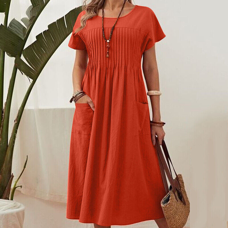 Person wearing a red dress holding a straw bag indoors.