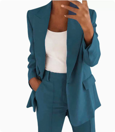 Teal suit jacket and pants worn by a person on a white background