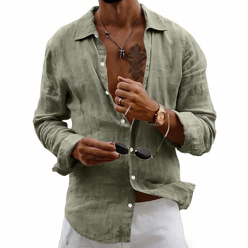Man wearing a light green shirt holding sunglasses on a white background