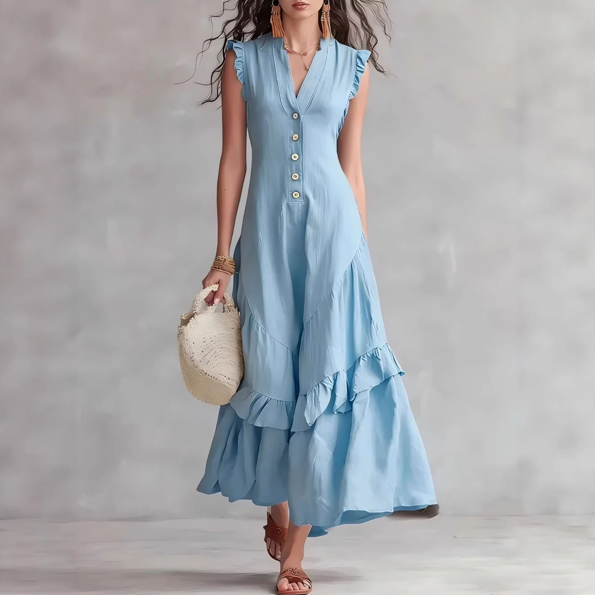 Woman wearing a light blue dress with ruffled sleeves and hem against a plain background