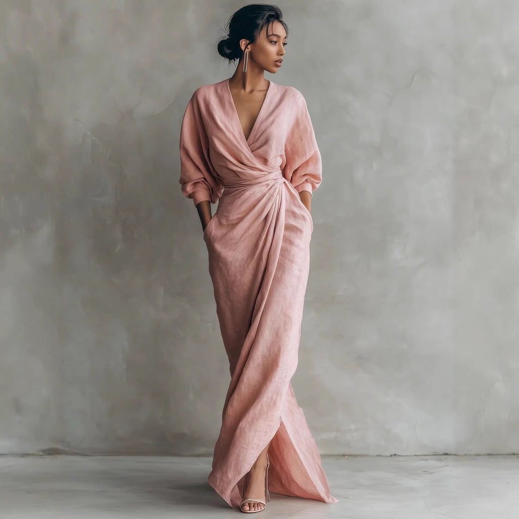 Woman wearing a pink draped dress against a plain background