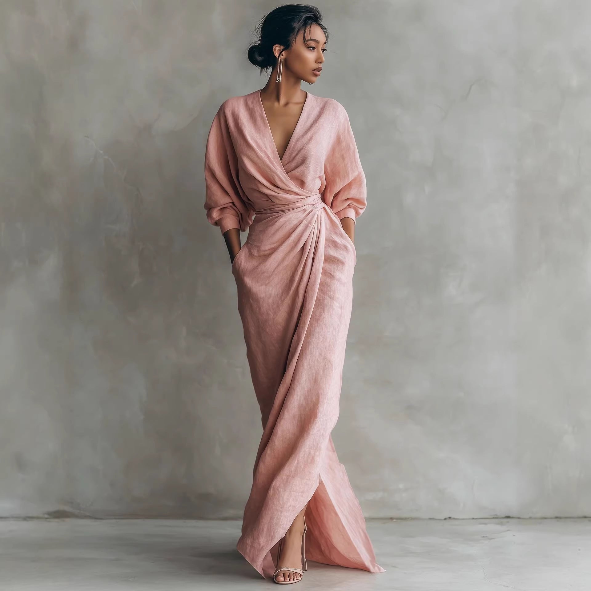 Woman wearing a pink draped dress against a plain background