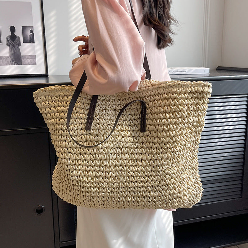Person holding a woven straw bag indoors