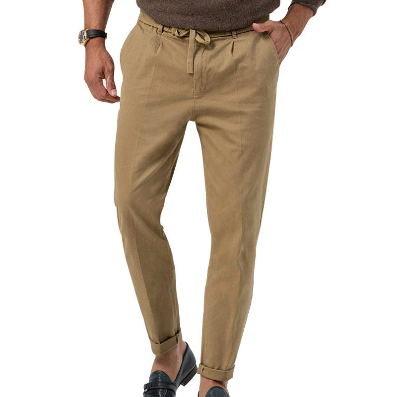 Beige pants worn by a person on a white background