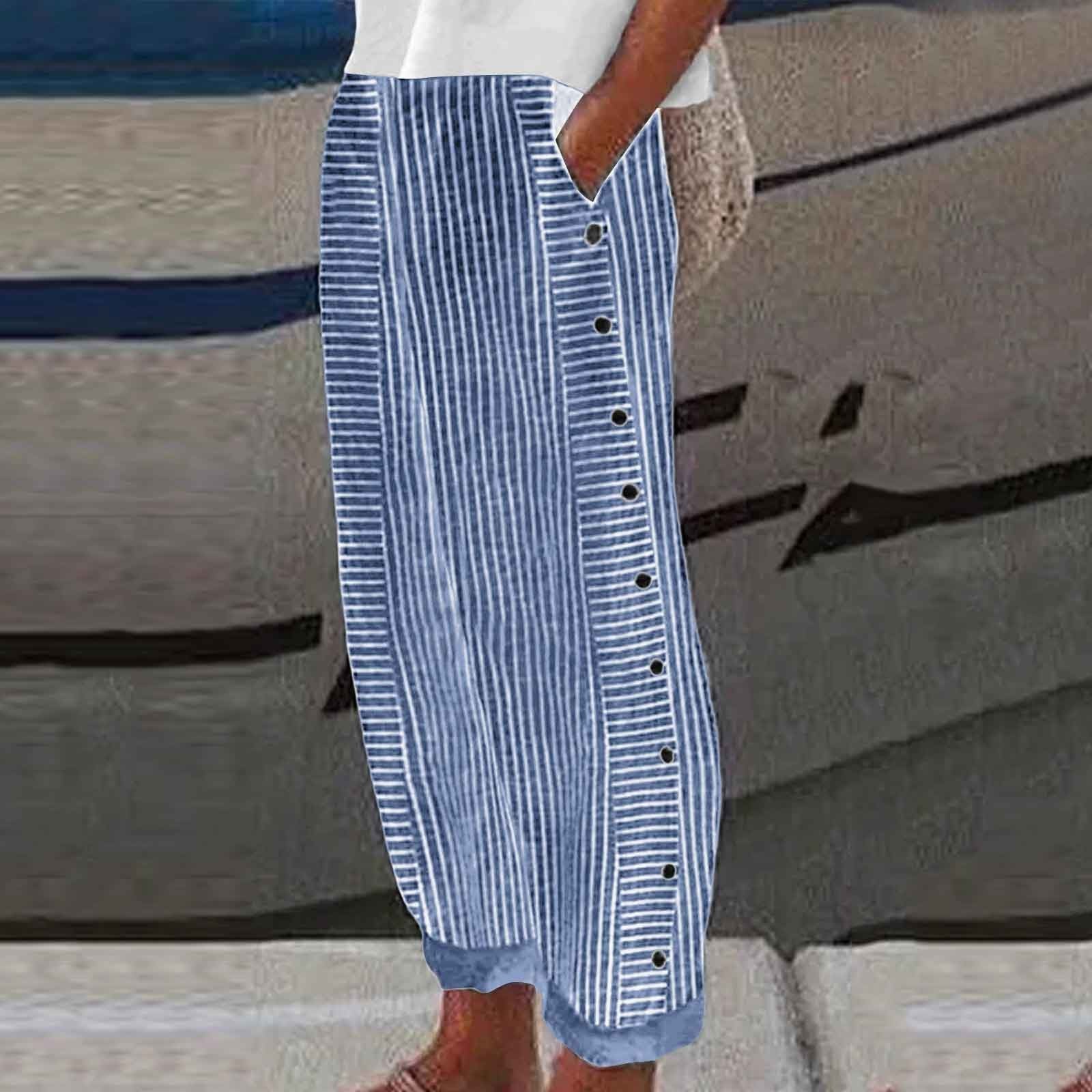 Person wearing a blue and white striped dress with buttons on a blurred background