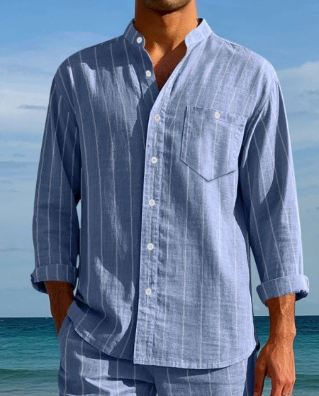 Man wearing a blue striped shirt and pants with a beach background
