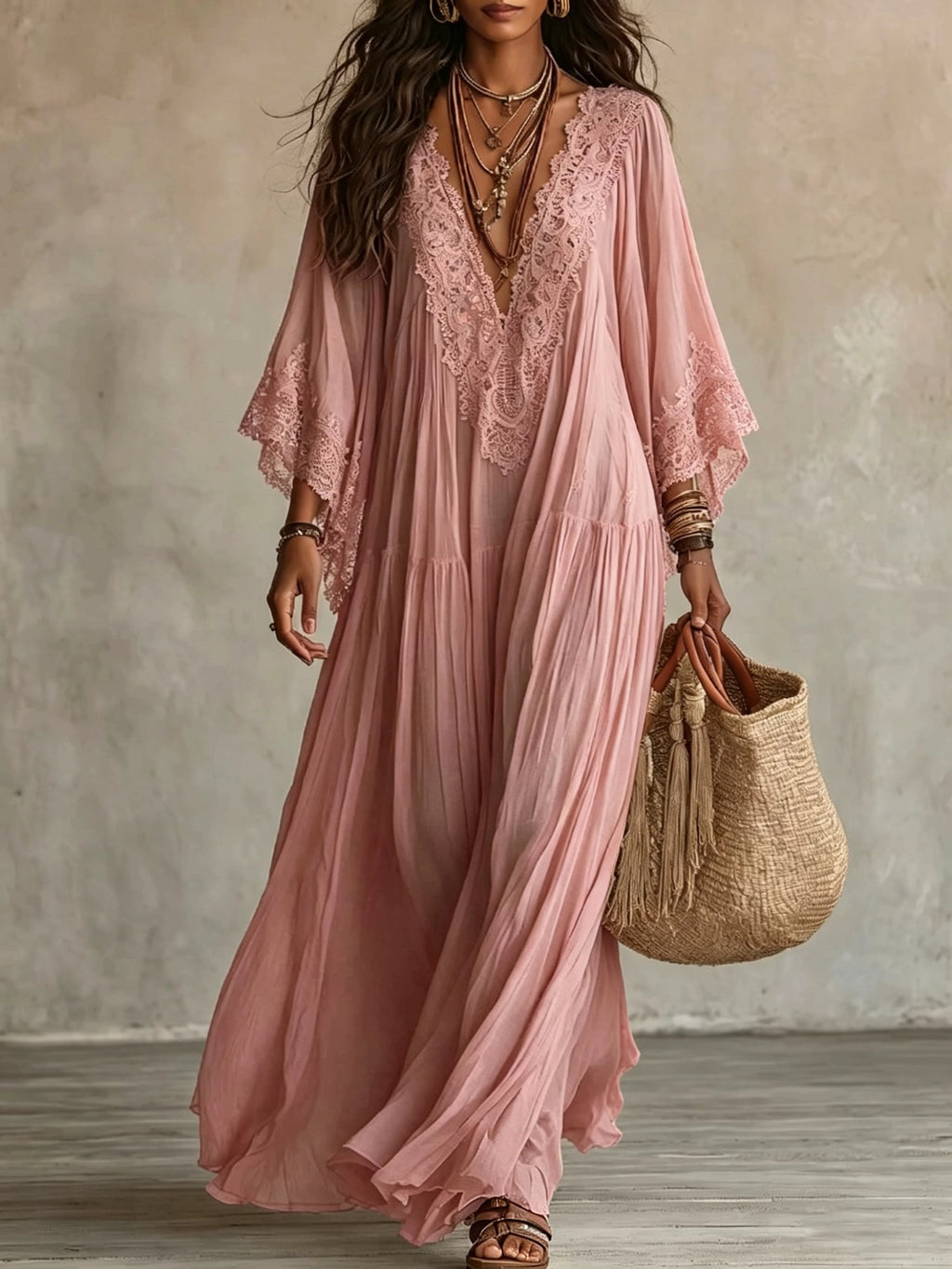 Woman wearing a pink lace dress holding a woven bag against a neutral background