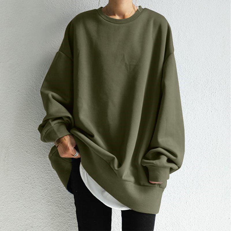 Person wearing an olive green oversized sweatshirt against a plain background