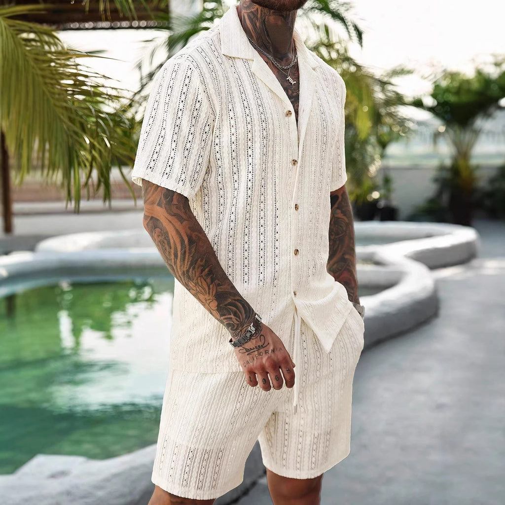 Man wearing a white embroidered shirt and shorts by a poolside.