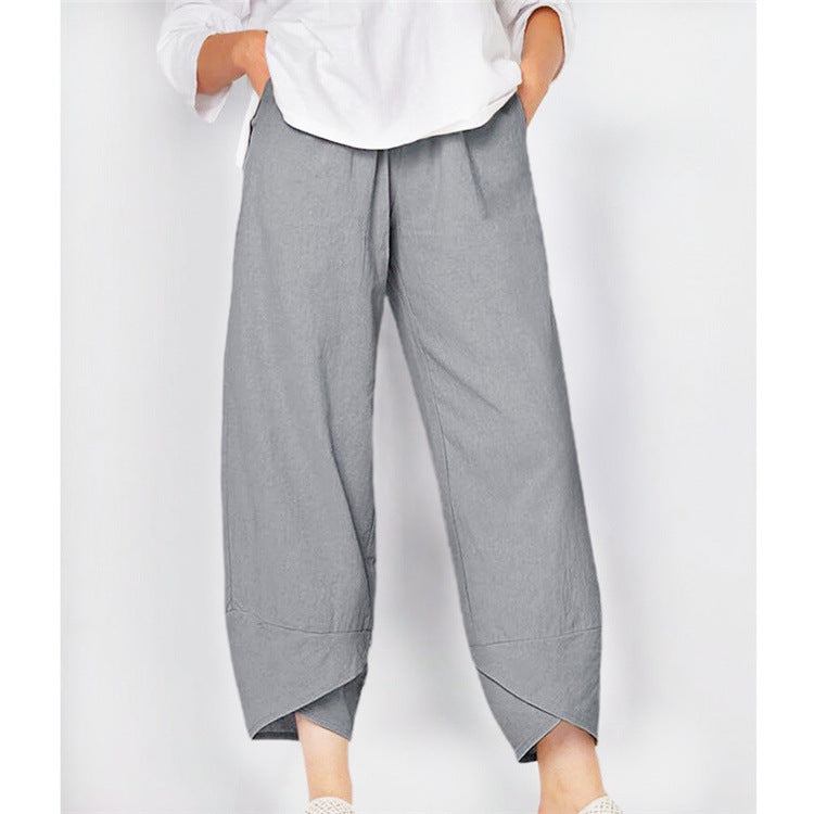 Gray wide-leg pants worn with a white shirt on a white background