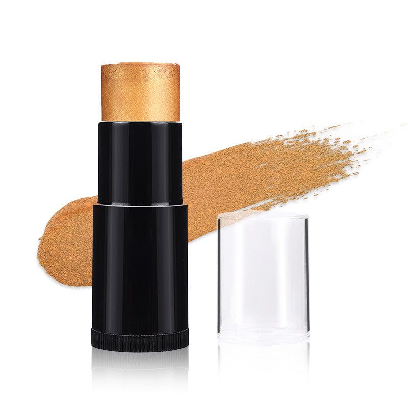 Black makeup stick with gold cap and swatch on white background