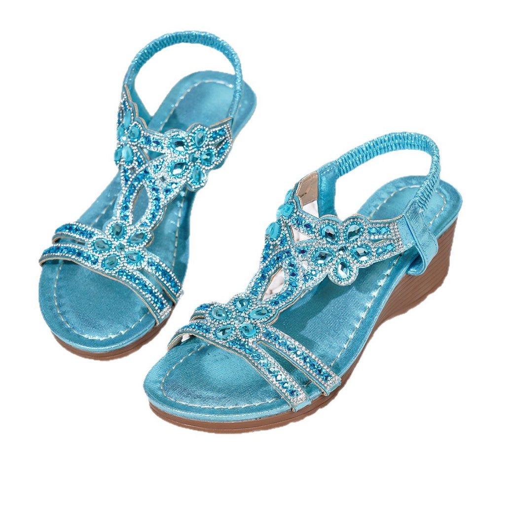 Pair of blue sandals with decorative embellishments on a white background