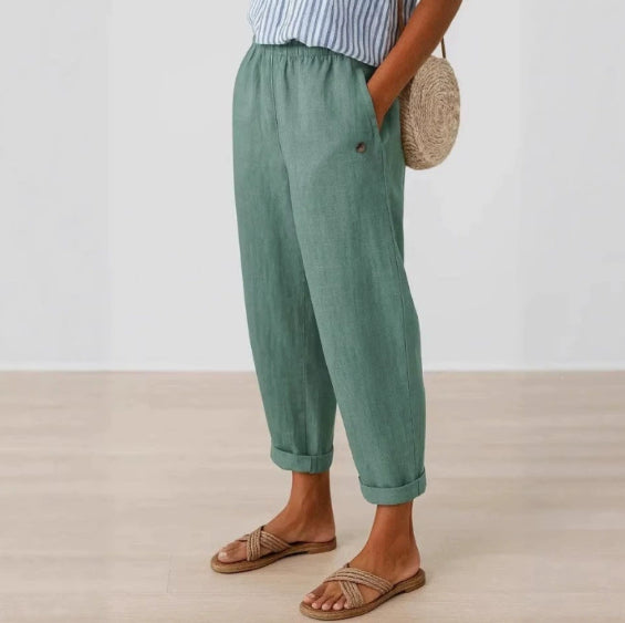 Person wearing green pants and sandals on a plain background