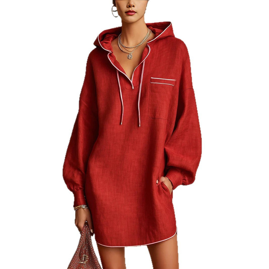 A woman models a red hooded longline shirt dress with white piping details, featuring a chest pocket and drawstrings, set against a plain white background.