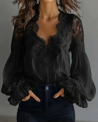 A woman wearing a black sheer long-sleeve blouse with a lace V-neckline and dark blue jeans, shown from the shoulders to the hips against a plain gray background.