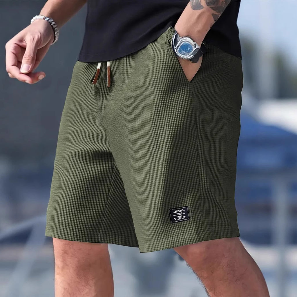 Person wearing green checkered shorts with a blurred background