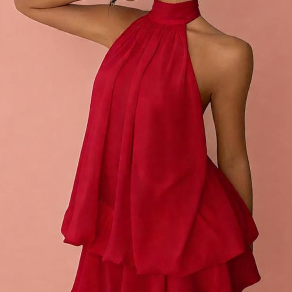 Red halter-neck dress on a model against a pink background