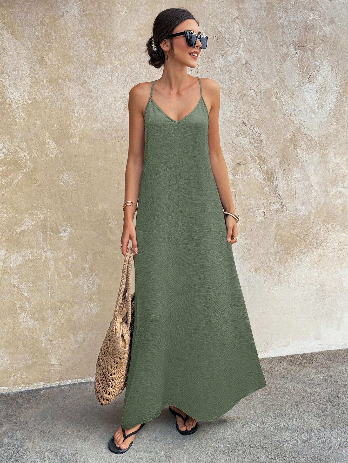 Woman wearing a green dress against a beige wall