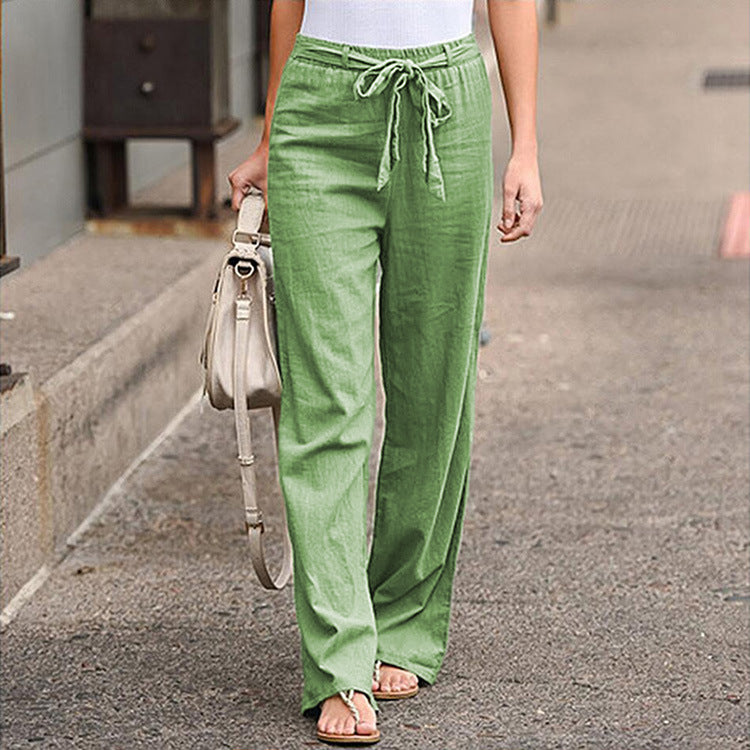 Person wearing green pants walking on a street.