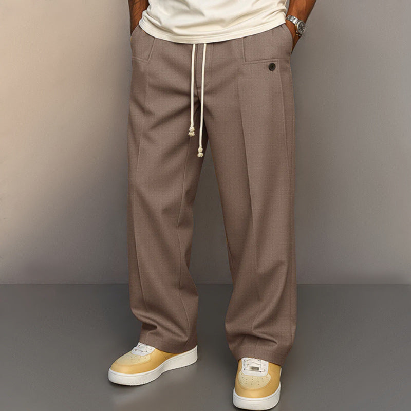 Person wearing brown pants with a plain background