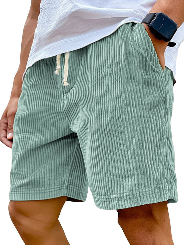 Green striped shorts worn by a person on a white background