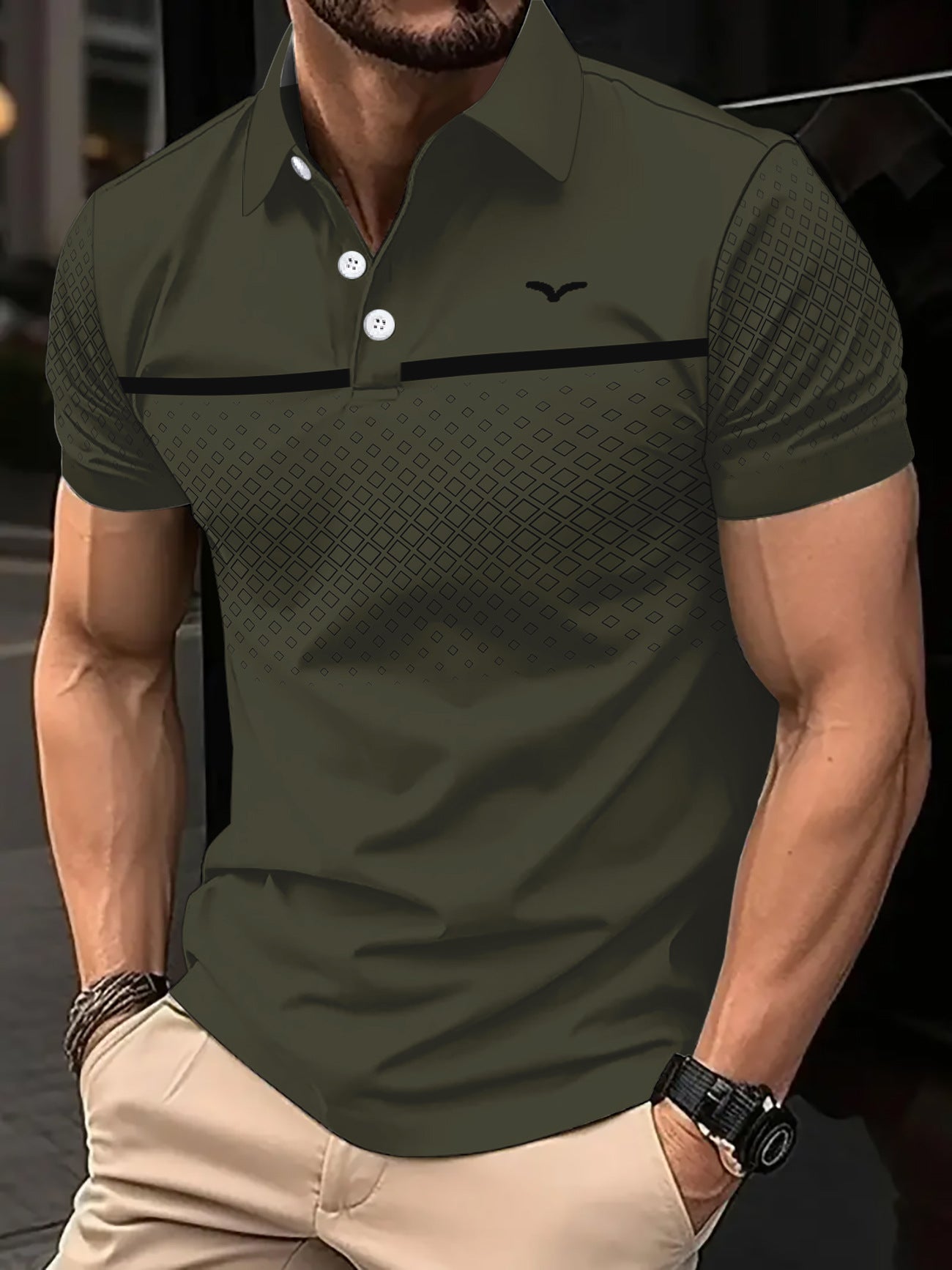 Man wearing a green polo shirt with a black stripe and logo, standing against a blurred background.
