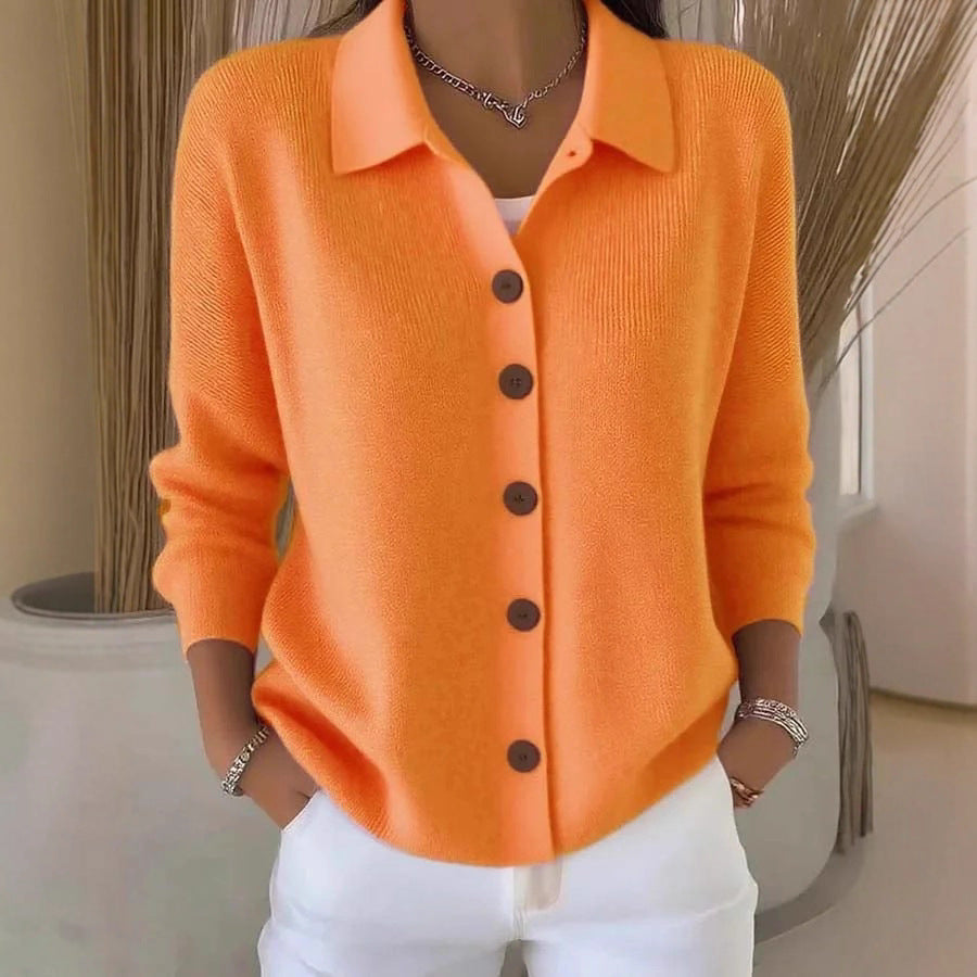 Person wearing an orange button-up shirt with a neutral background