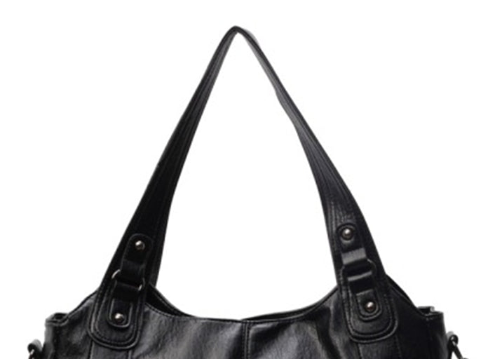 Black leather handbag with shoulder straps on a white background