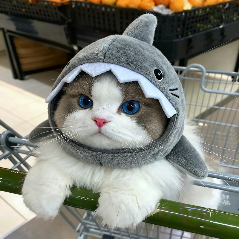 Cat wearing a shark costume inside a shopping cart