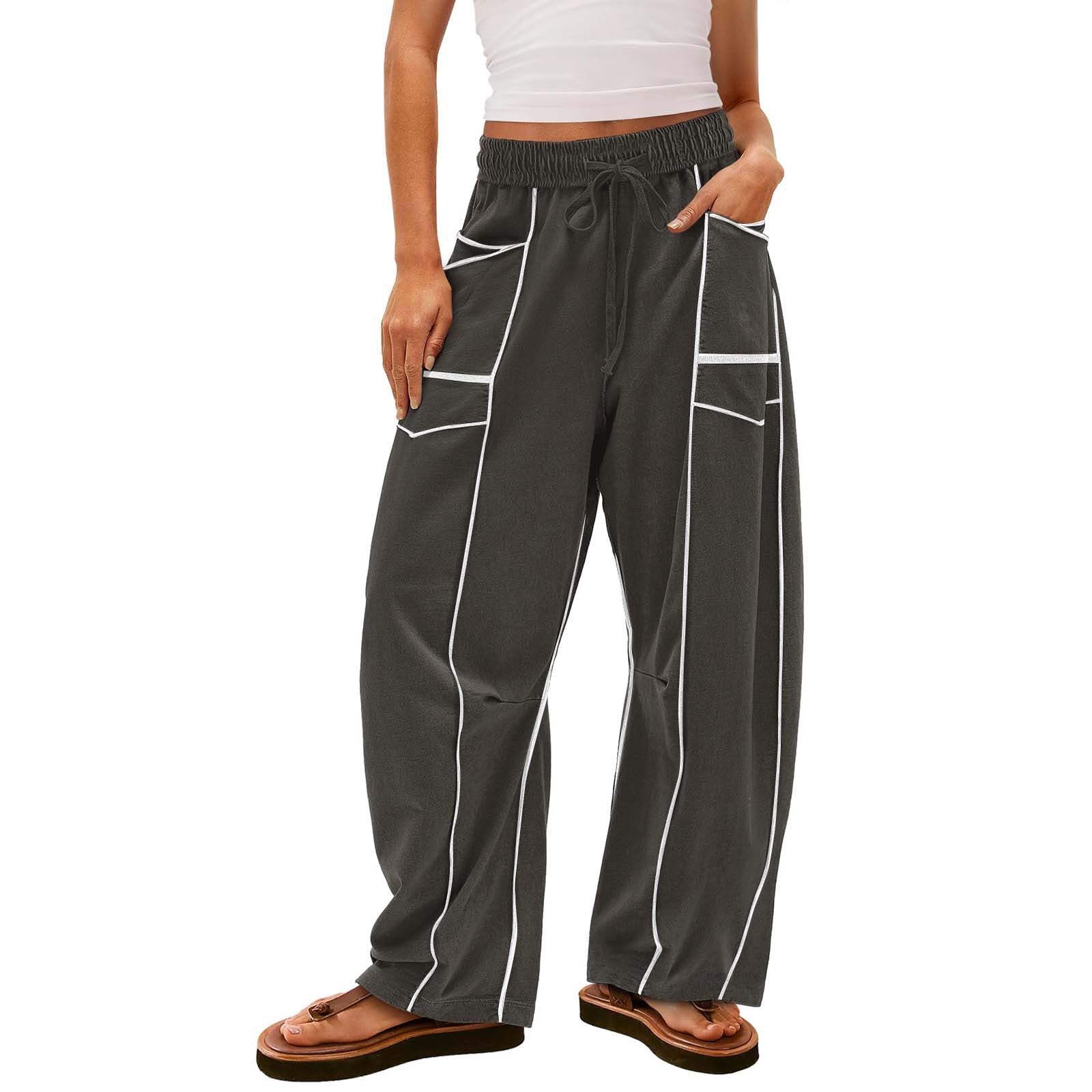 Person wearing dark gray pants with white piping on a white background