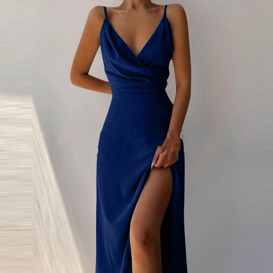 Woman wearing a blue evening gown with a slit on a neutral background