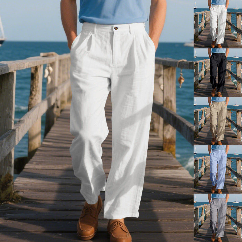 Person wearing white pants standing on a wooden dock by the ocean.
