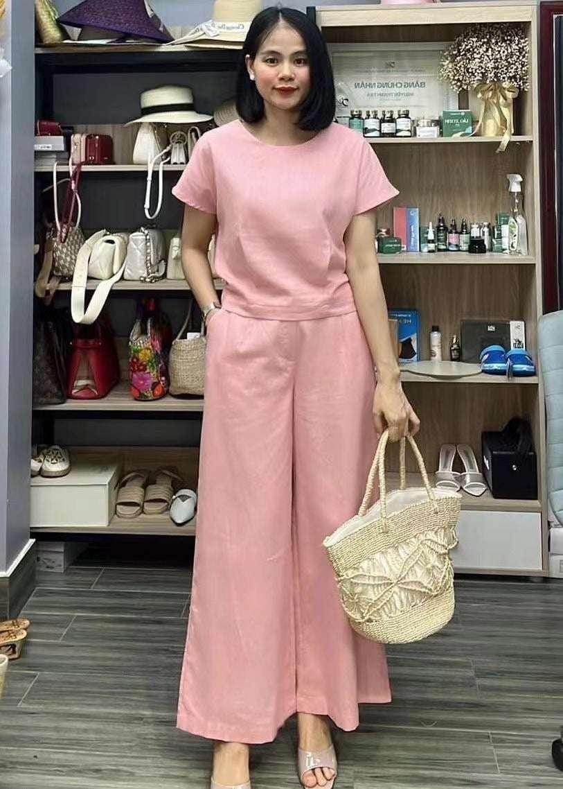 Woman wearing pink jumpsuit and holding woven tote bag in fashion boutique, ZA-Zola UK style