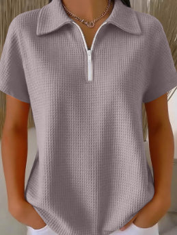 Person wearing a textured gray polo shirt with a zipper.
