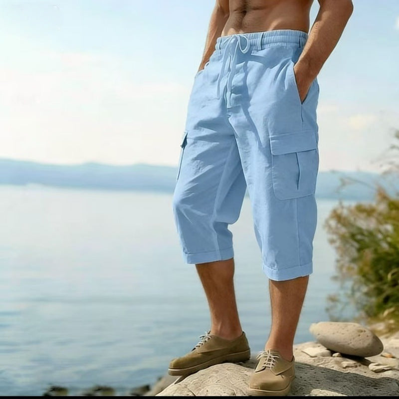 Person wearing light blue cargo shorts standing by a body of water.