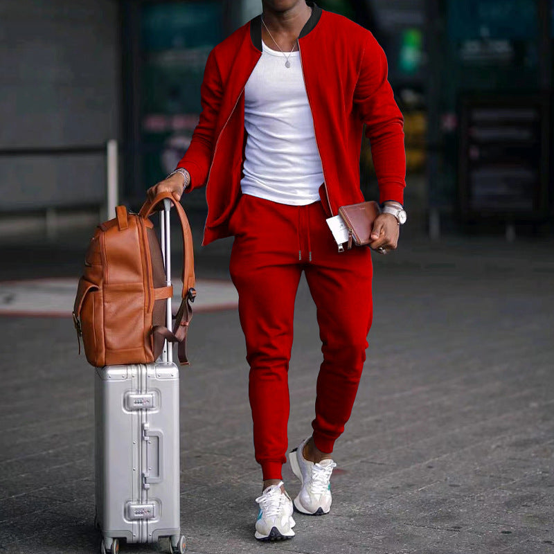 Person in red tracksuit with suitcase and brown backpack on a blurred street background