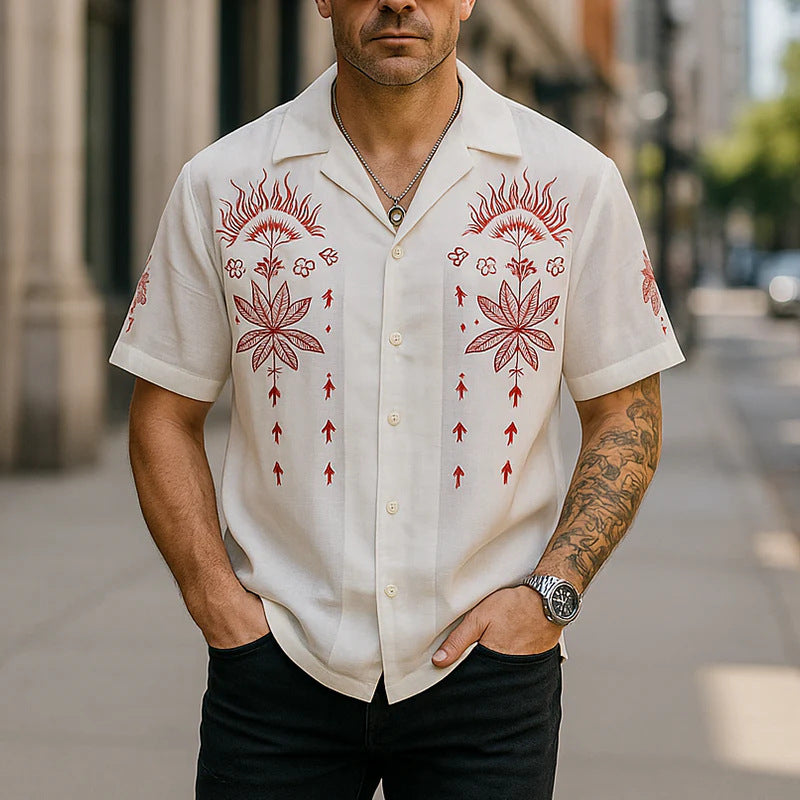 Man wearing a white shirt with red floral patterns on a city street.