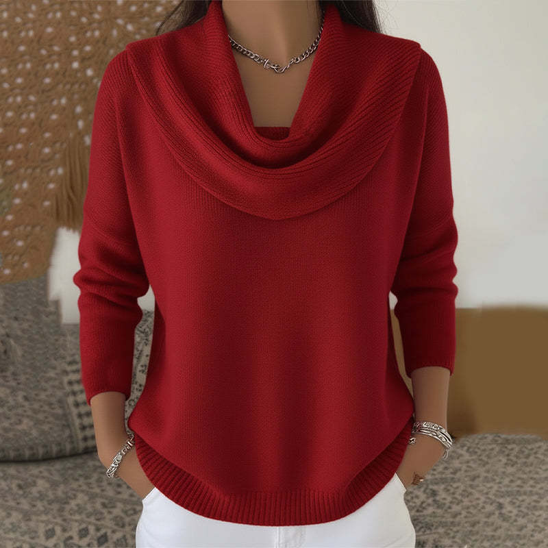 Red cowl-neck sweater worn by a person with a blurred background