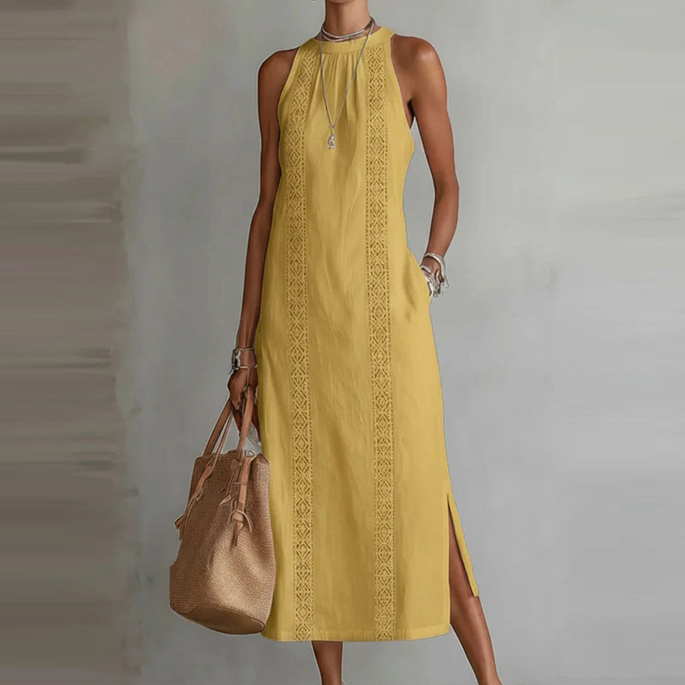 Woman wearing a yellow dress with intricate patterns, holding a brown handbag against a plain background.