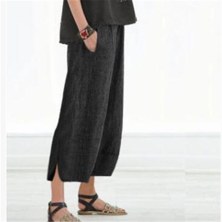 Person wearing dark gray wide-leg pants on a white background