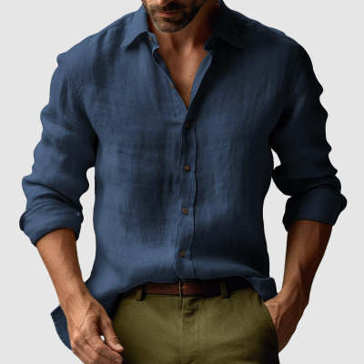 Man wearing a blue button-up shirt and green pants on a light gray background