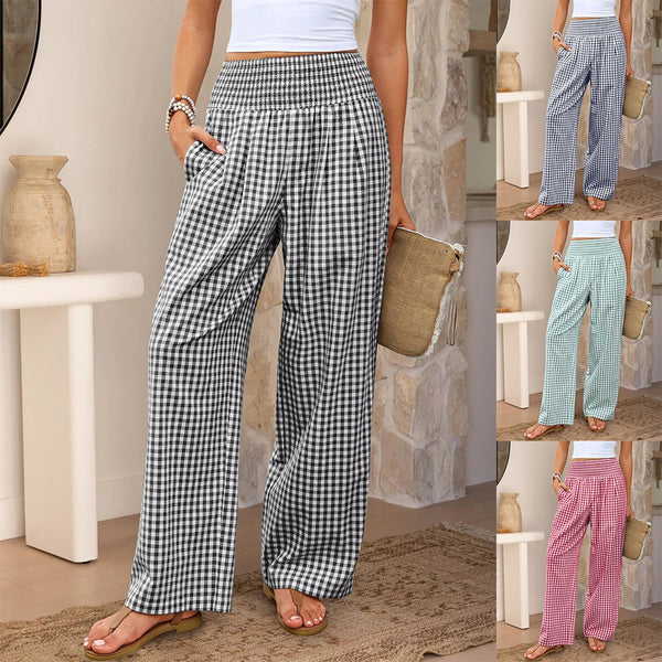 Woman wearing checkered pants in various colors with a neutral background.