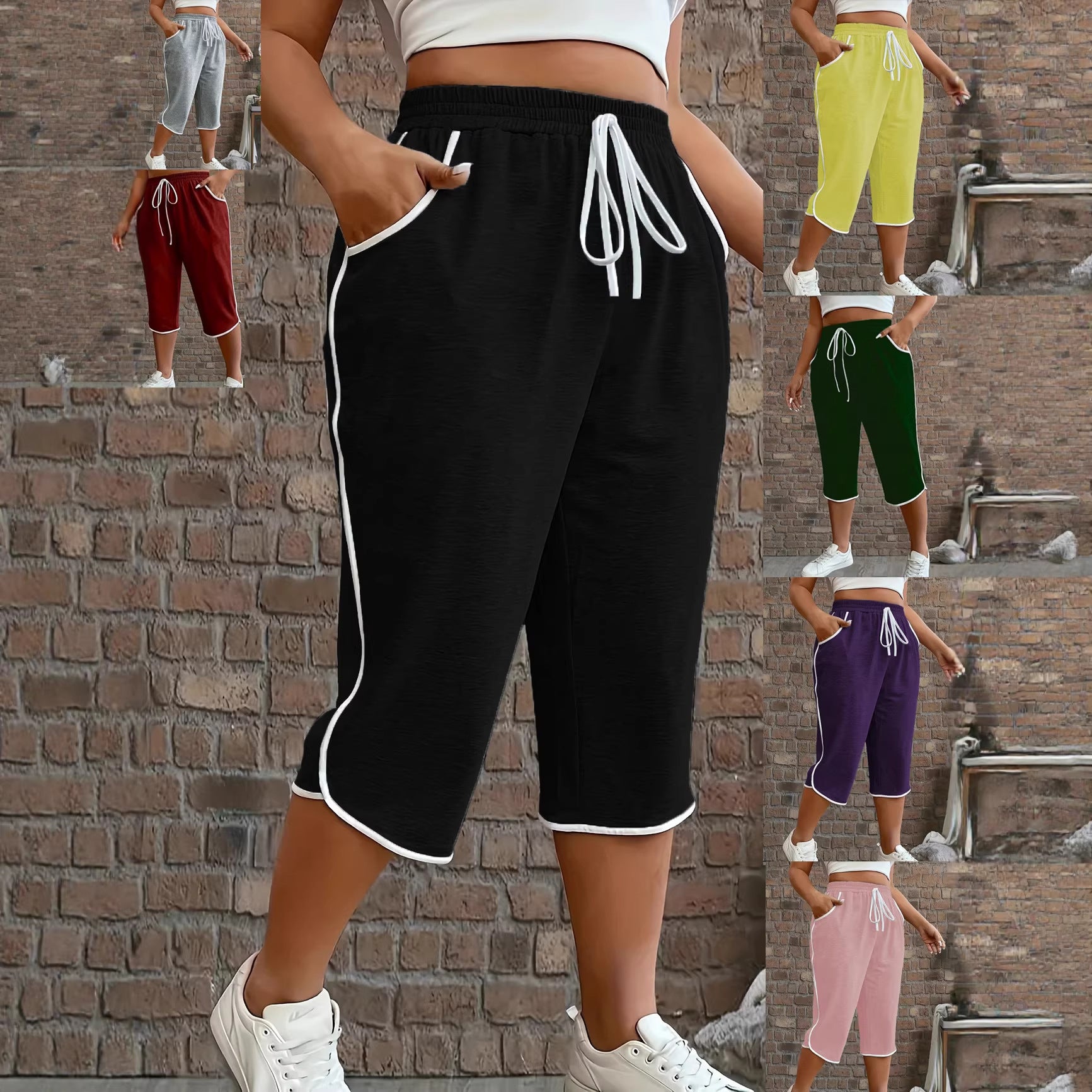 Black capri pants with white drawstrings worn by a person against a brick wall.