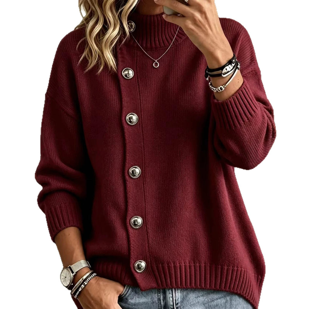 A woman wearing a ribbed knit cardigan sweater in burgundy with large silver buttons, paired with blue jeans and accessorized with bracelets and a necklace, shown against a plain white background.