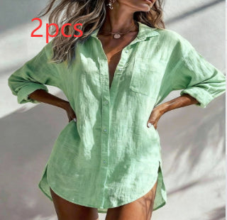 A woman wearing a light mint green linen button-up shirt with rolled-up sleeves and a relaxed fit, shown against a light wall with soft shadows. Red text overlay reads '2pcs'.