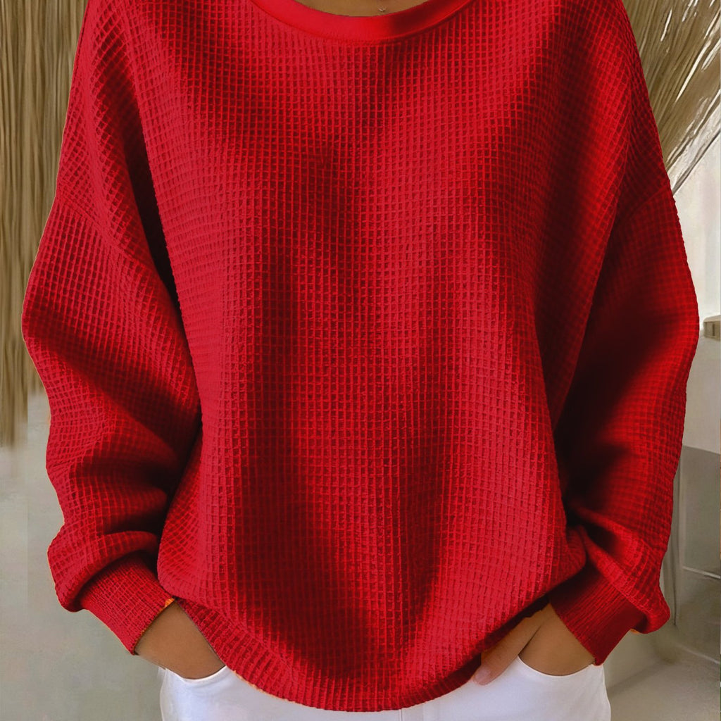 Red textured sweater worn by a person indoors.