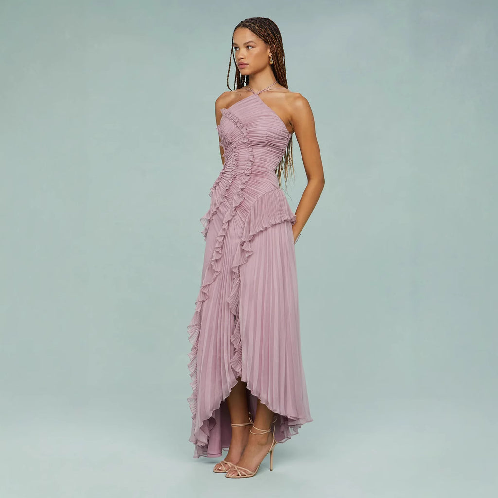 Woman wearing a pink one-shoulder dress with ruffles on a light blue background