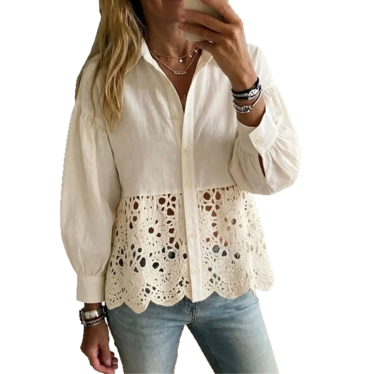 A woman wearing a cream-colored long-sleeve blouse with a solid upper section and an eyelet lace overlay at the hem, paired with light blue jeans.