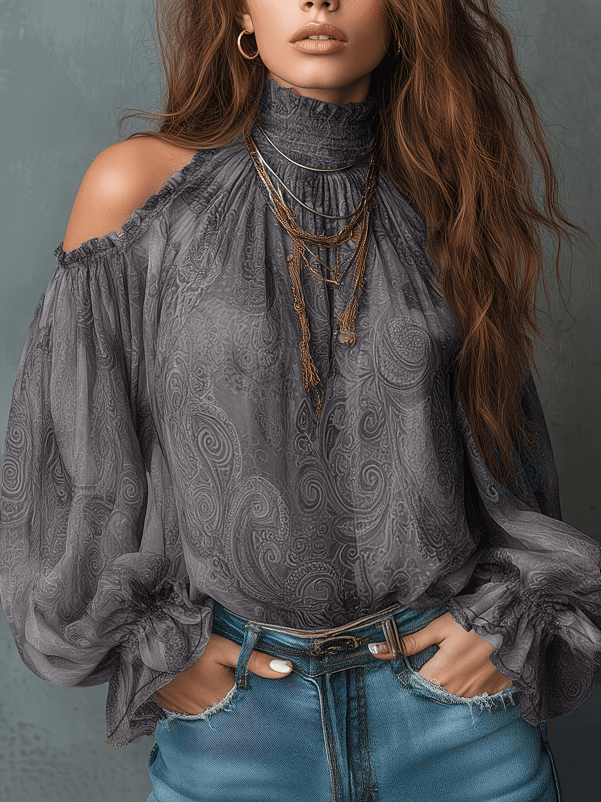 Woman wearing a gray patterned blouse and blue jeans against a gray background