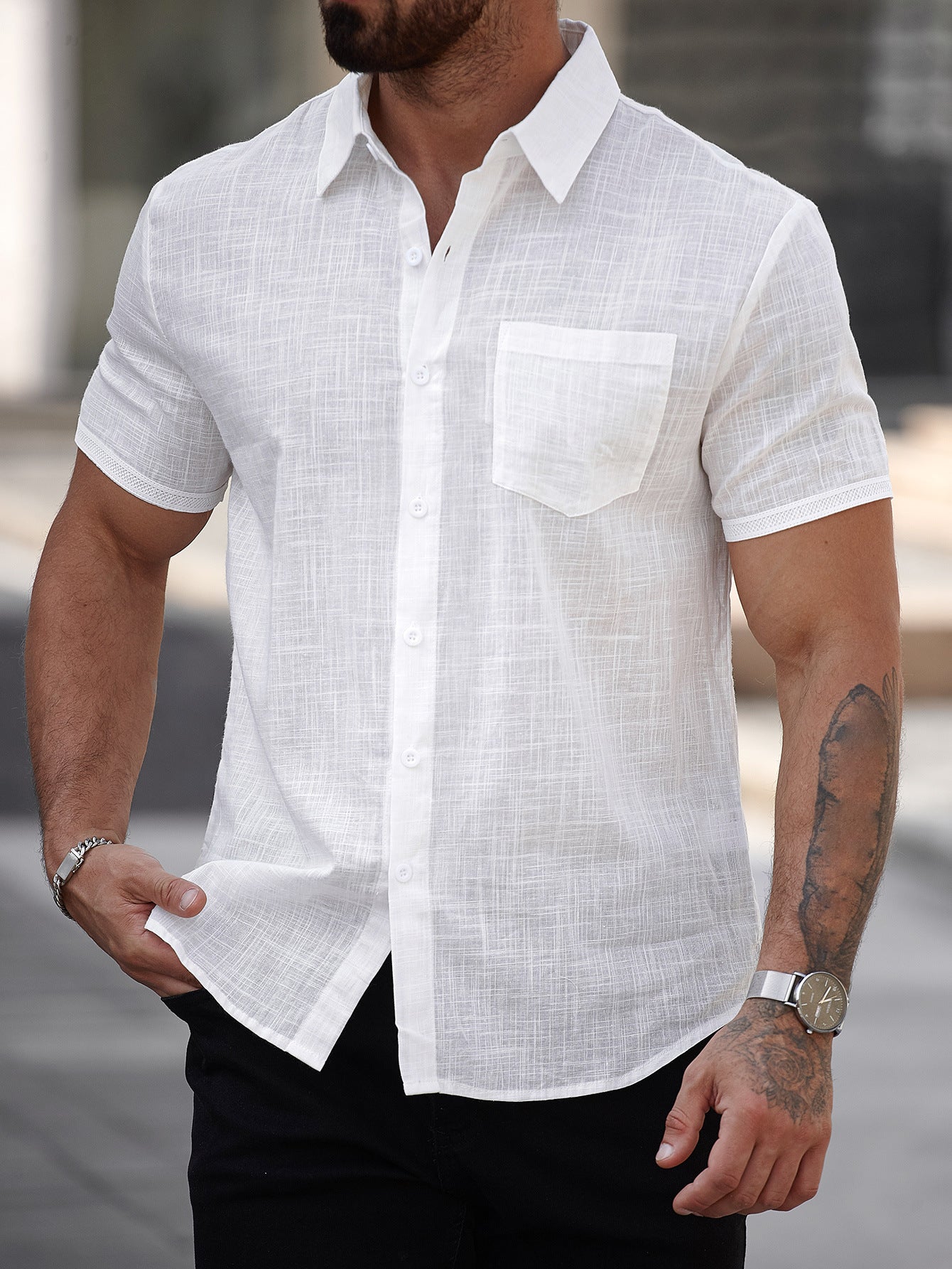 Man wearing a white short-sleeve shirt with a blurred background